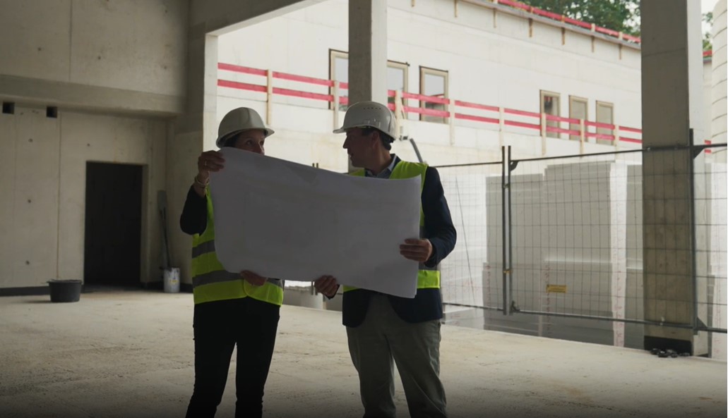 Kollegen auf der Baustelle mit Bauplan